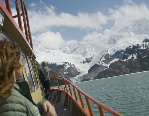 Mujer en el bote con vista al glaciar en Tierra del Fuego