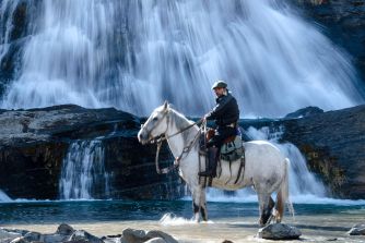 Patagonian gaucho riding a white horse, Torres del Paine.