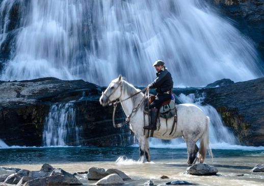 Patagonian gaucho riding a white horse, Torres del Paine.