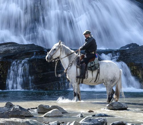 Gaúcho guiding a horseback exploration through the wilderness of Torres del Paine National Park, part of Explora's multi-destination offerings.