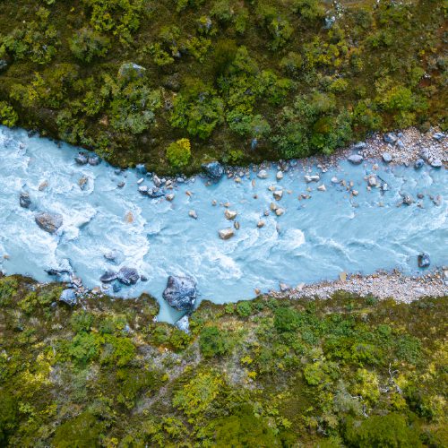 http://An%20aerial%20view%20of%20a%20milky%20blue%20river%20cutting%20through%20forest