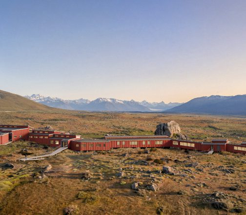 Patagonia hotel complex set in an open steppe landscape with mountain views under a clear sky, overlooking Perito Moreno Glacier
