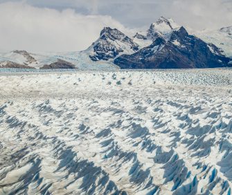 Vast expanse of the Perito Moreno Glacier with jagged blue-white ice formations and mountain backdrop near El Calafate, Argentine Patagonia